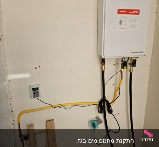 מחמם מים גז מחובר לצינורות וקופסת חשמל